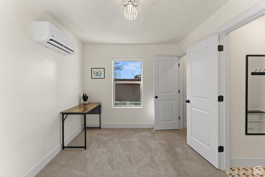 Corridor with light carpet, an AC wall unit, and baseboards