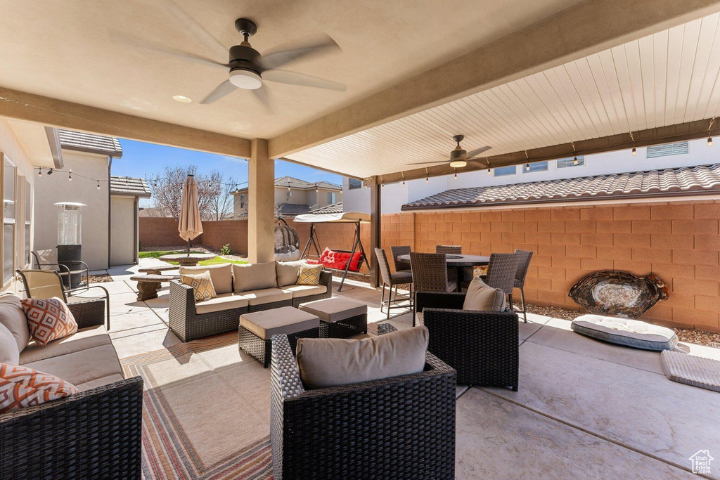 View of patio with outdoor dining space, ceiling fan, an outdoor hangout area, and fence