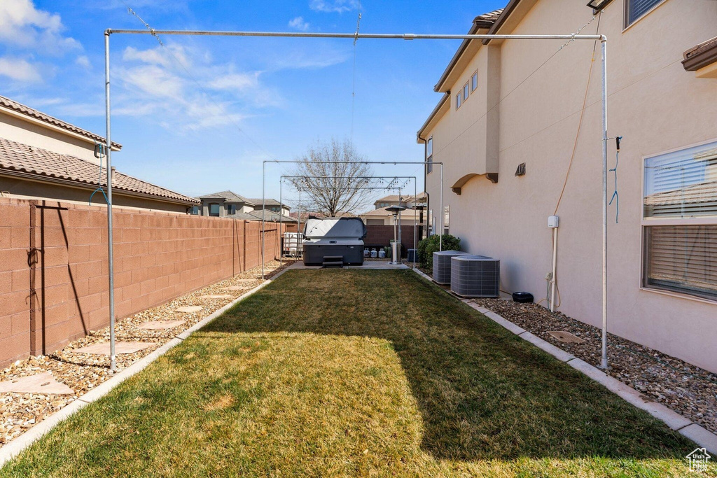 View of yard with central AC and a fenced backyard