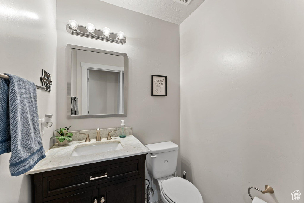 Half bathroom featuring toilet and vanity