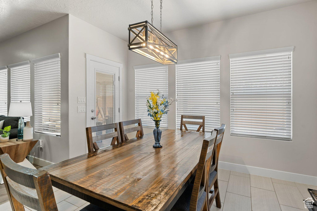Dining area featuring an inviting chandelier, tile patterned flooring, and baseboards