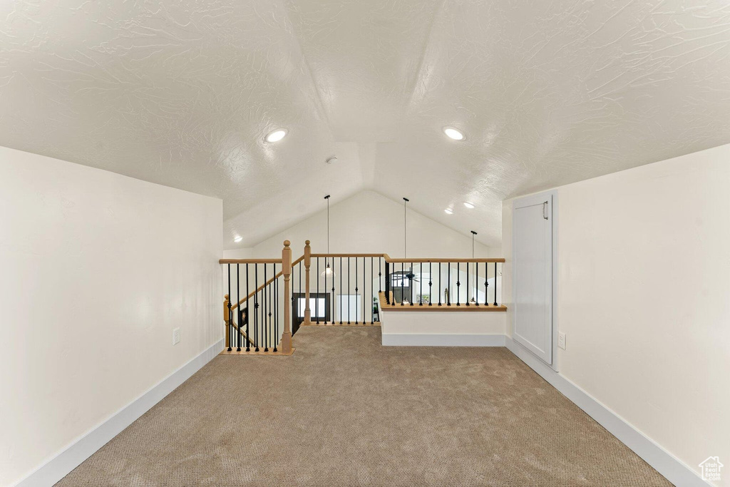 Bonus room with a textured ceiling, carpet, baseboards, recessed lighting, and vaulted ceiling