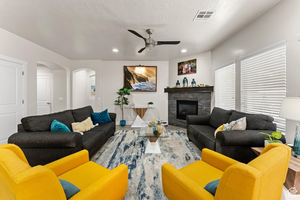 Living room with visible vents, wood finished floors, recessed lighting, a ceiling fan, and arched walkways