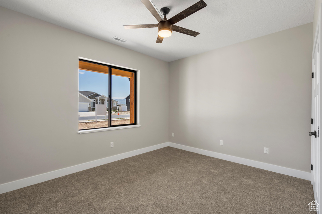 Spare room with ceiling fan, carpet, and baseboards