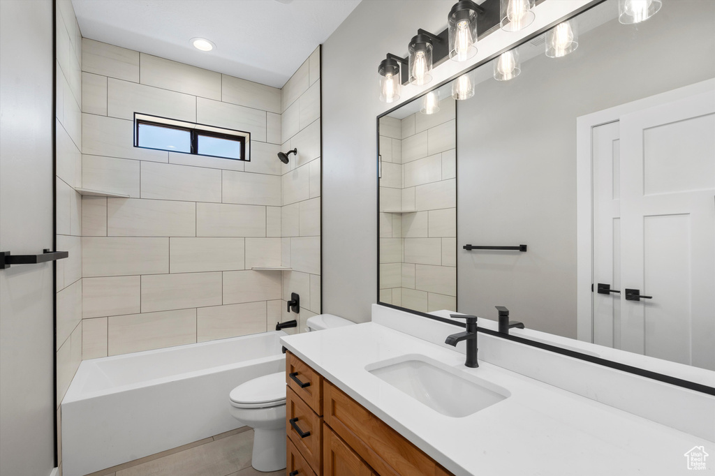 Bathroom featuring toilet, vanity, and shower / tub combination