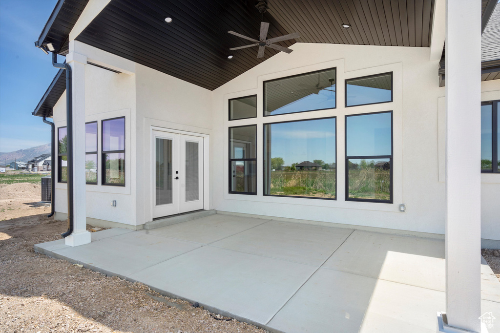 View of patio / terrace with french doors, a ceiling fan, and a mountain view