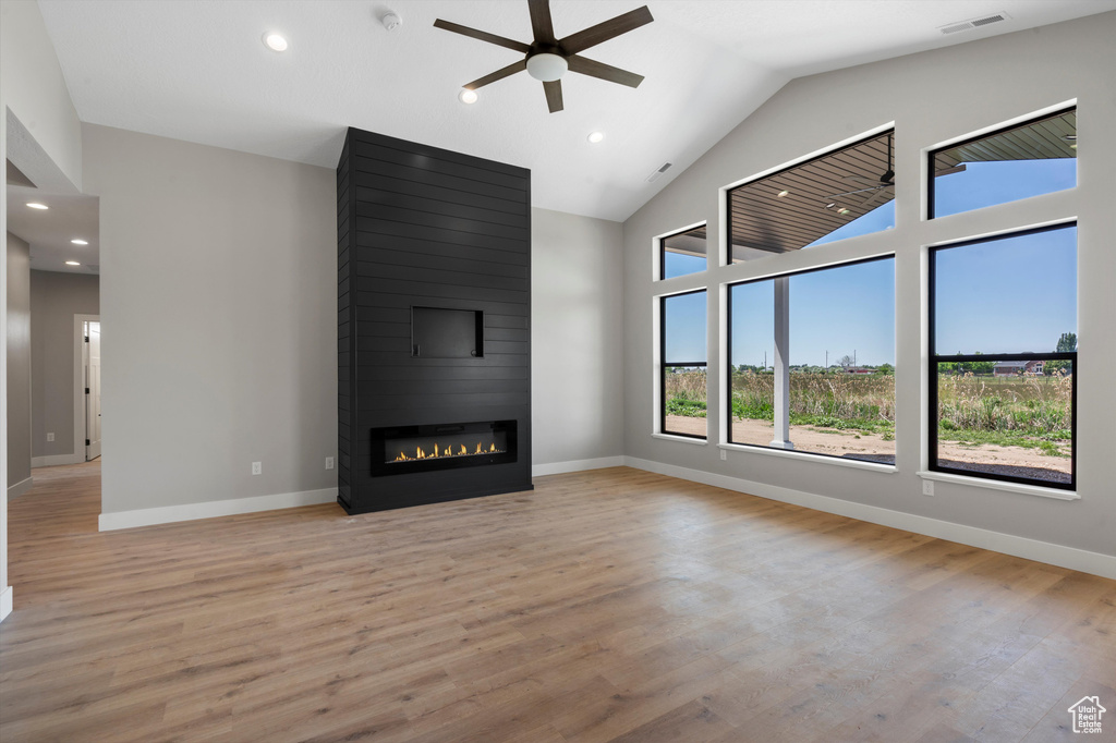 Unfurnished living room with a ceiling fan, recessed lighting, a fireplace, light wood-type flooring, and baseboards