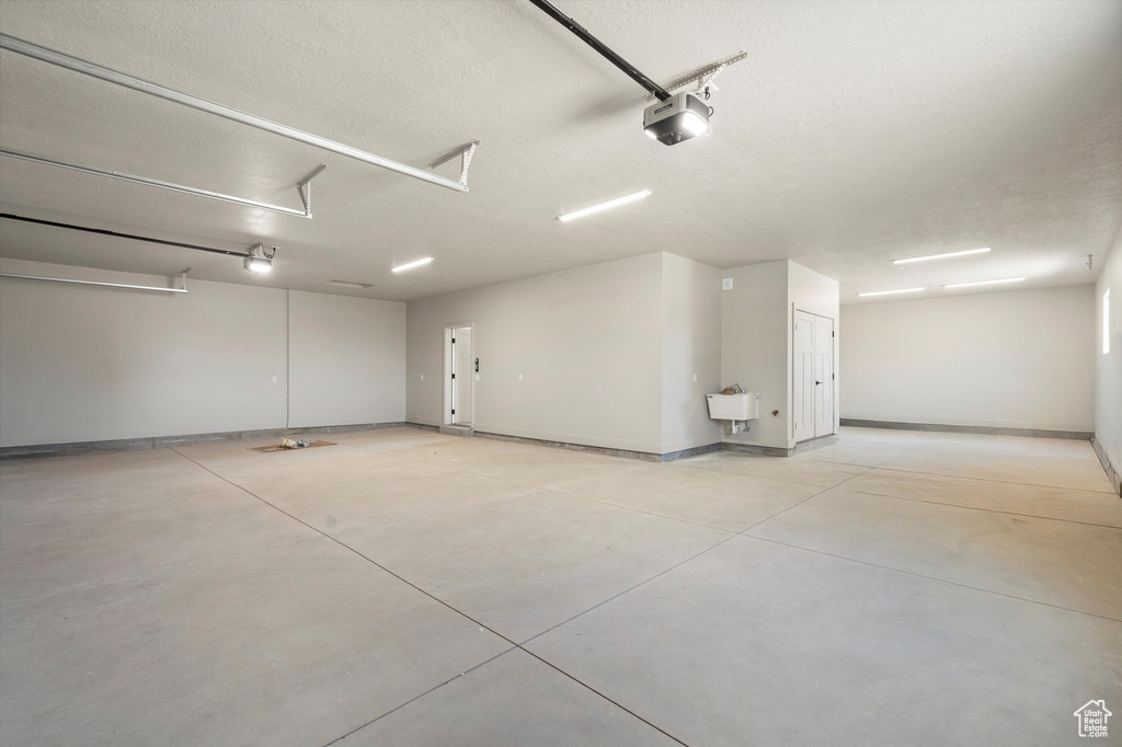 Garage with baseboards and a garage door opener