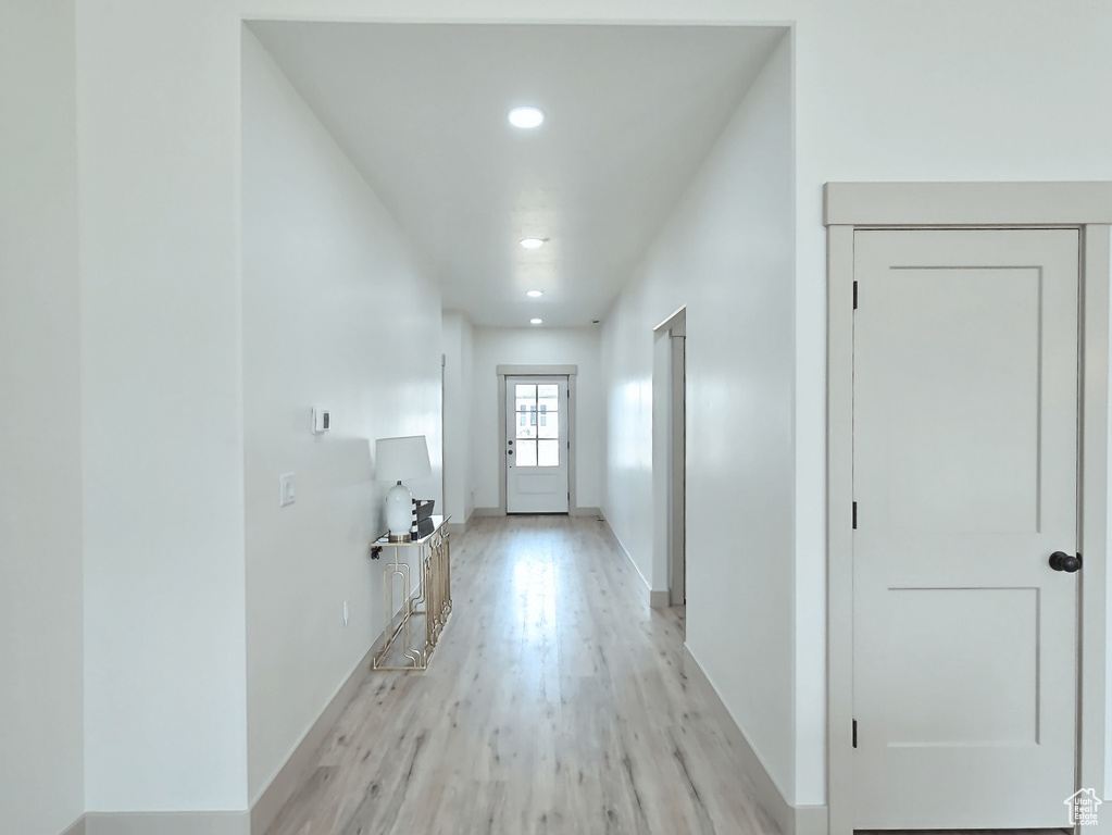 Hallway featuring baseboards, recessed lighting, and light wood-style floors