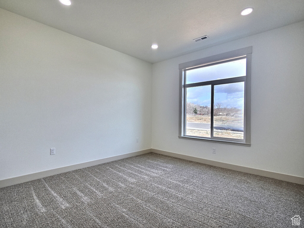 Spare room with baseboards, carpet floors, visible vents, and recessed lighting