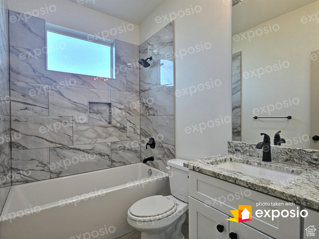 Full bath with shower / bathing tub combination, vanity, and toilet