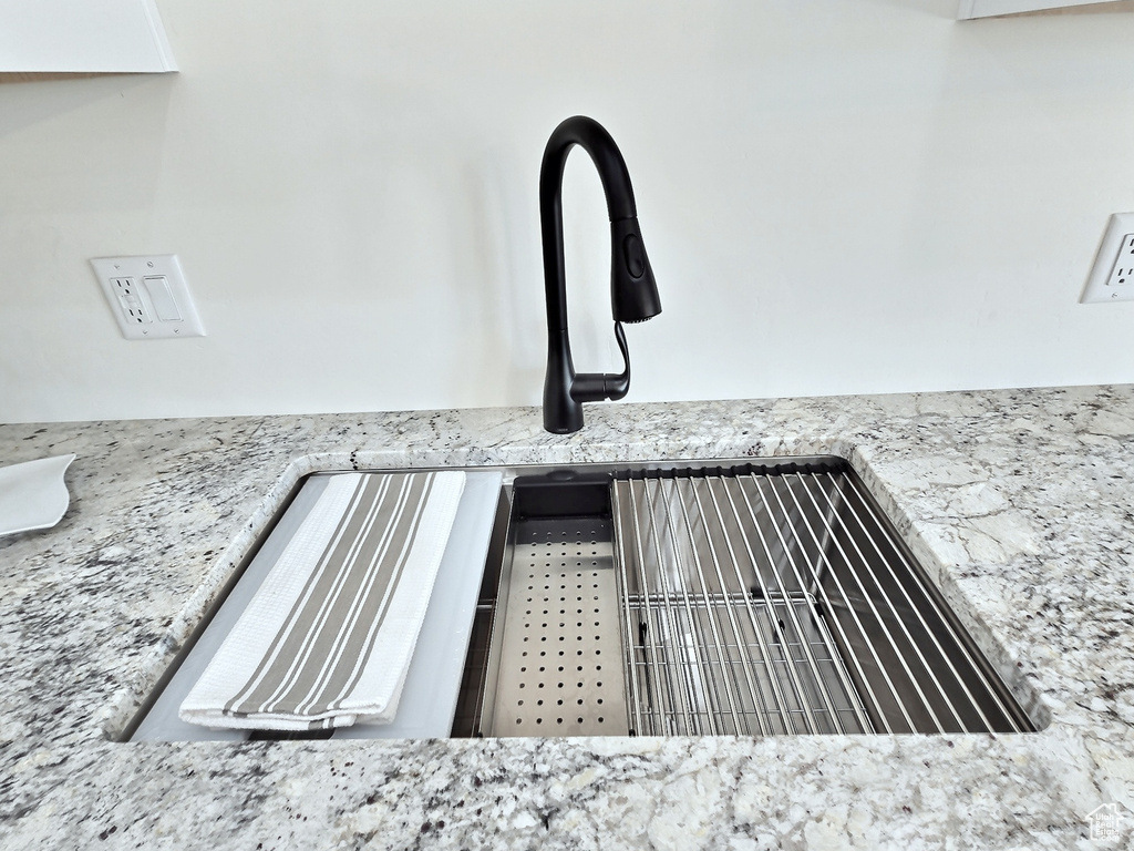 Interior details featuring light stone countertops and a sink