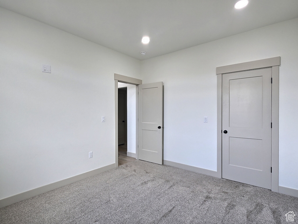 Unfurnished bedroom featuring baseboards, recessed lighting, and light colored carpet