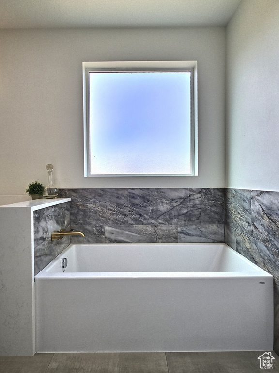 Bathroom featuring a wealth of natural light and a garden tub