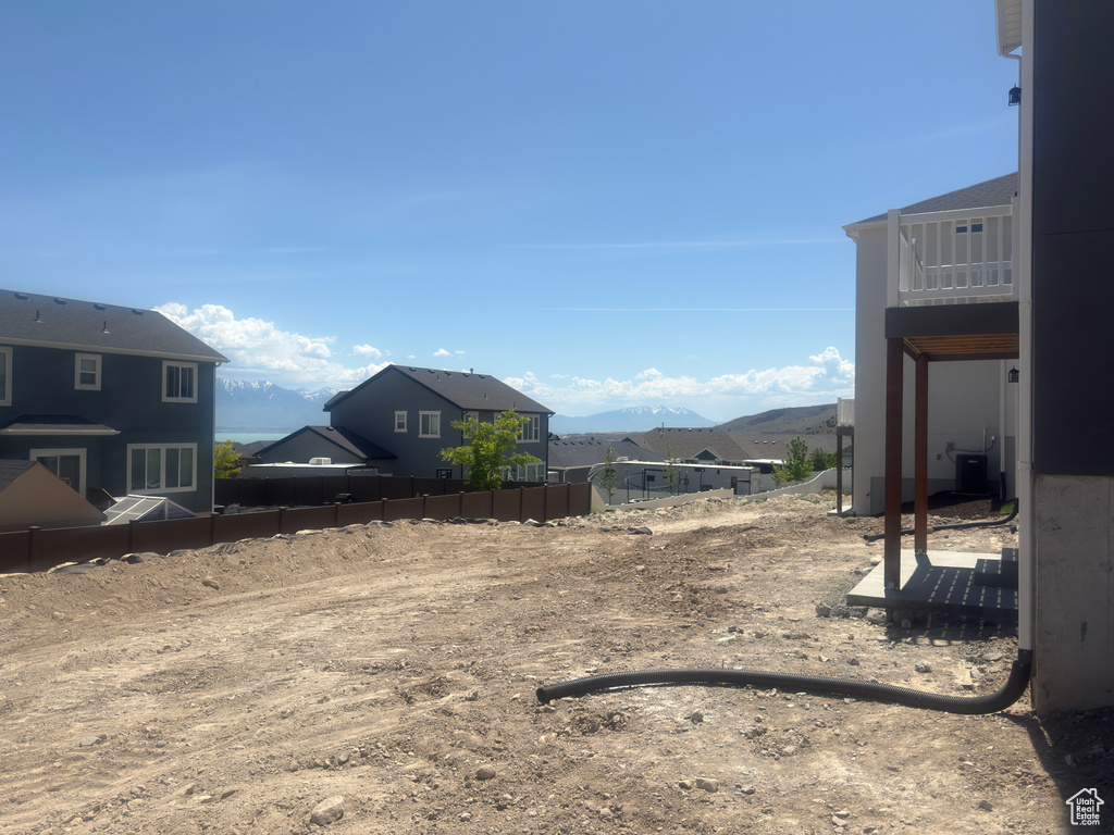View of yard with a mountain view, a balcony, cooling unit, and a residential view