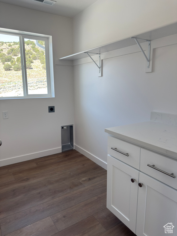 Laundry area featuring hookup for an electric dryer, baseboards, and dark wood-type flooring