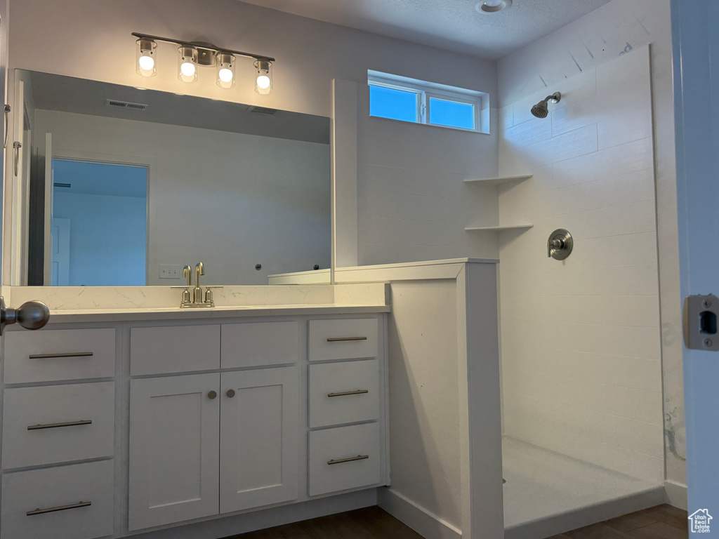 Bathroom featuring walk in shower and vanity