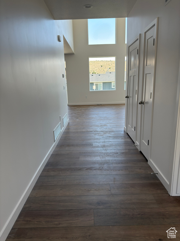 Hall with dark wood-style flooring and baseboards