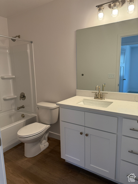 Full bath featuring toilet, wood finished floors, vanity, and tub / shower combination