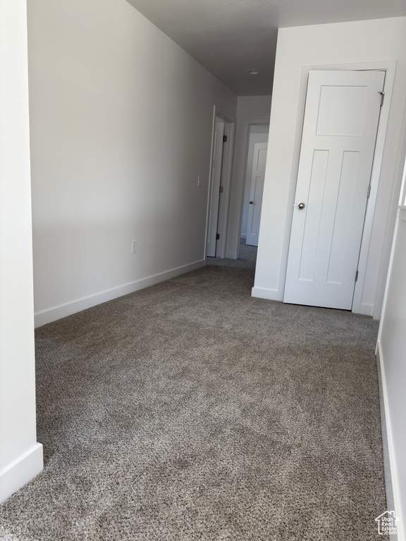 Unfurnished bedroom with carpet floors and baseboards
