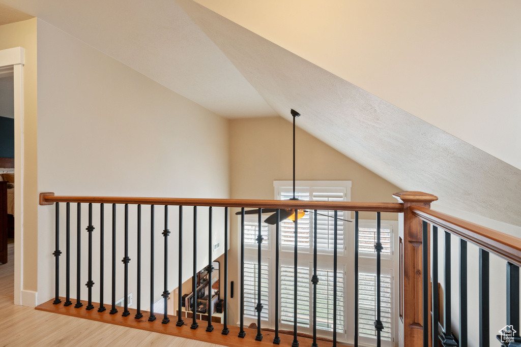 Hallway featuring wood finished floors and vaulted ceiling