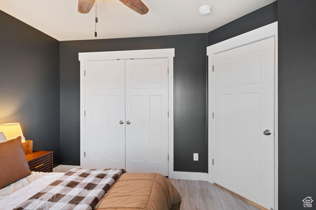 Bedroom featuring a closet, baseboards, ceiling fan, and light wood-style flooring