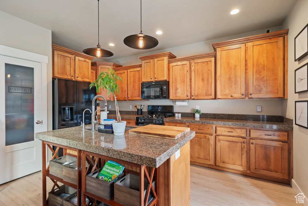 Kitchen featuring a sink, recessed lighting, black appliances, and light wood-style floors
