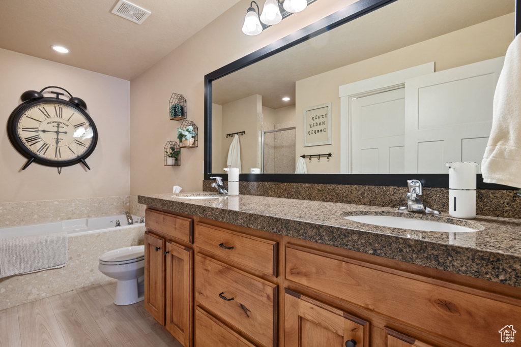 Full bath featuring a sink, a stall shower, a garden tub, visible vents, and double vanity