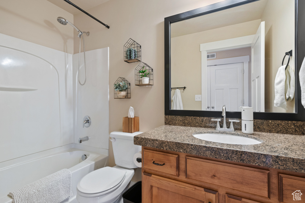 Bathroom featuring toilet, visible vents, shower / bathing tub combination, and vanity