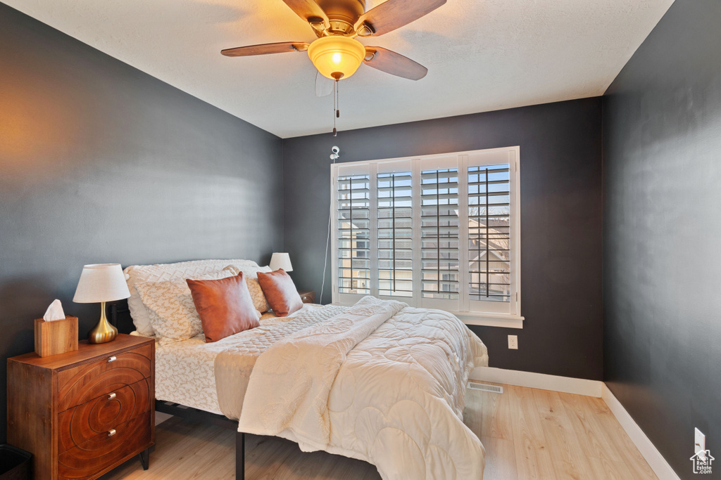 Bedroom with baseboards, wood finished floors, and a ceiling fan