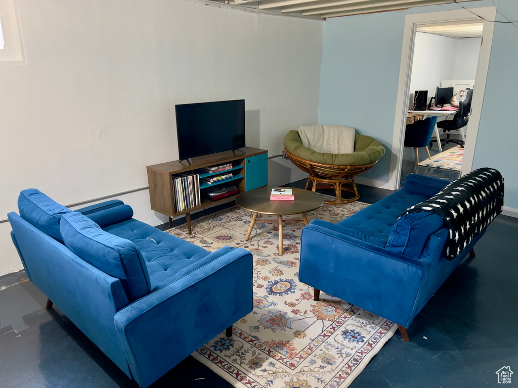 Living area with a desk and finished concrete flooring