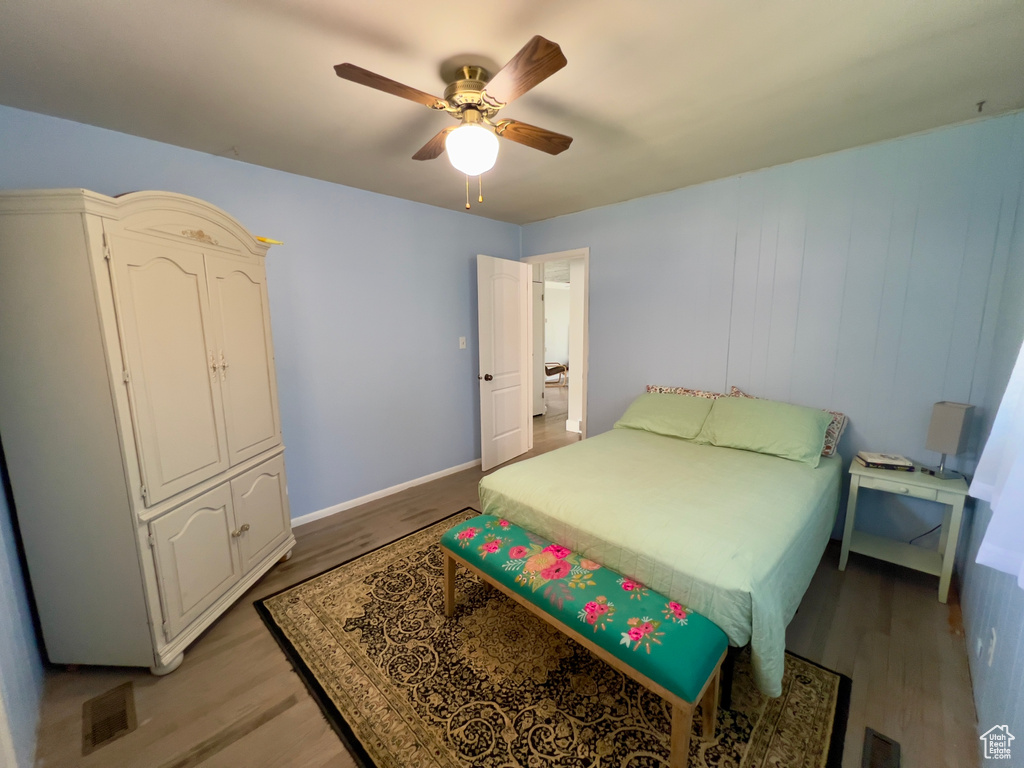 Bedroom with light wood-style flooring, ceiling fan, and baseboards