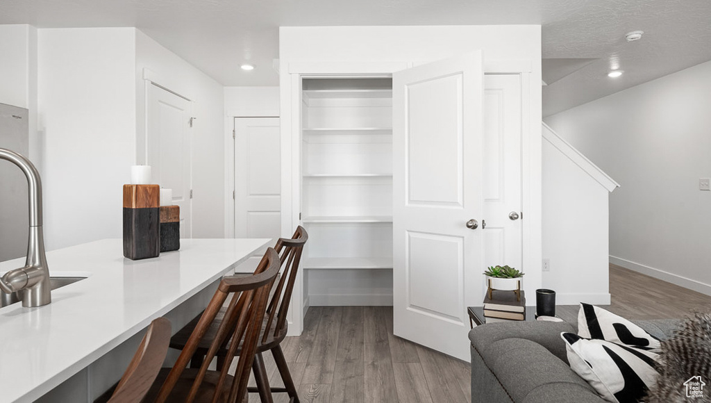 Office area with baseboards, wood finished floors, recessed lighting, and a textured ceiling