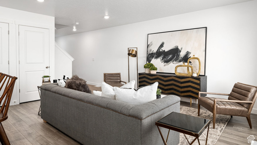 Living area with baseboards, wood finished floors, and recessed lighting
