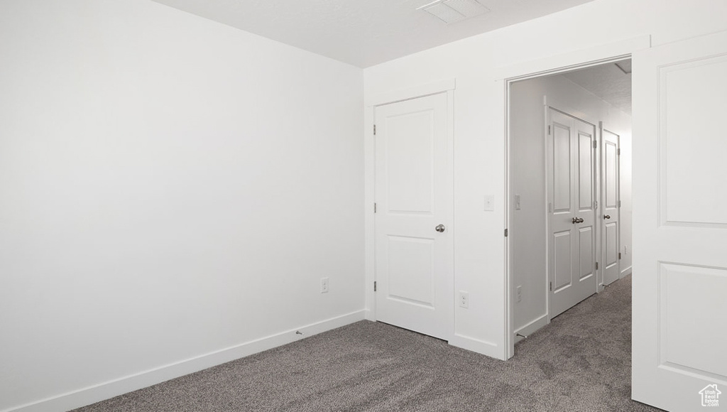 Unfurnished bedroom featuring carpet, baseboards, and visible vents