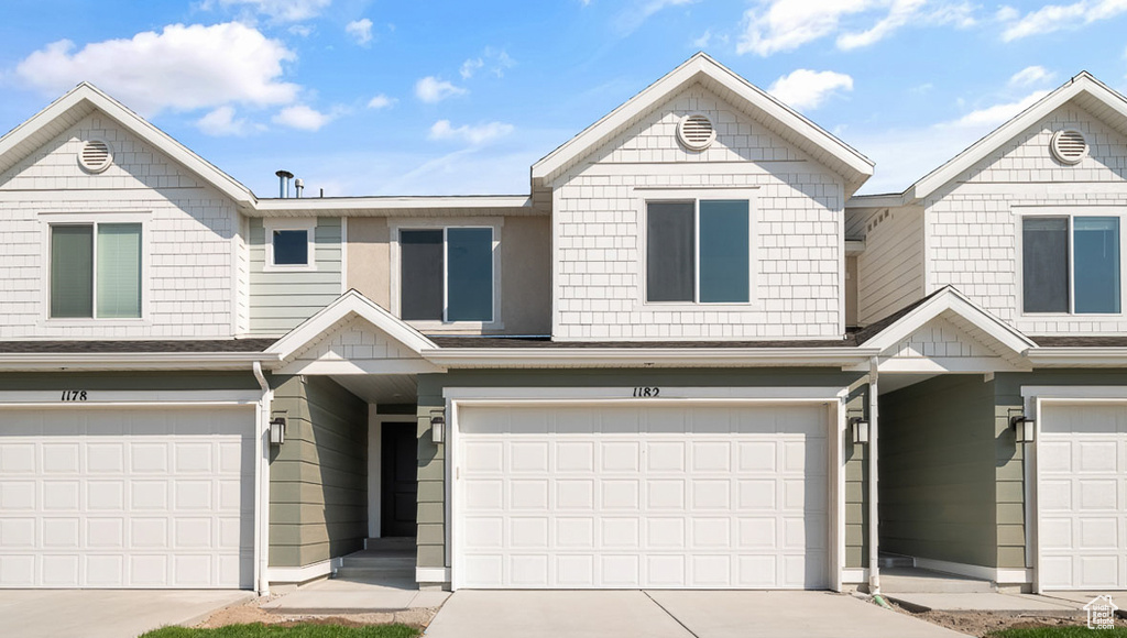 Townhome / multi-family property featuring driveway and a garage