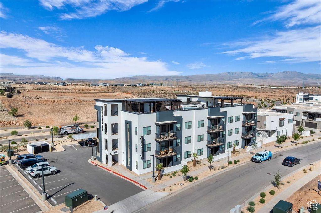 View of building exterior featuring uncovered parking and a mountain view