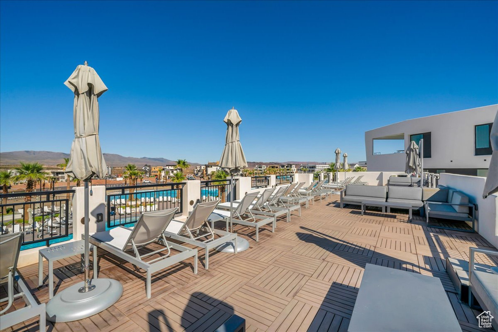 Deck featuring a community pool, a mountain view, and outdoor lounge area