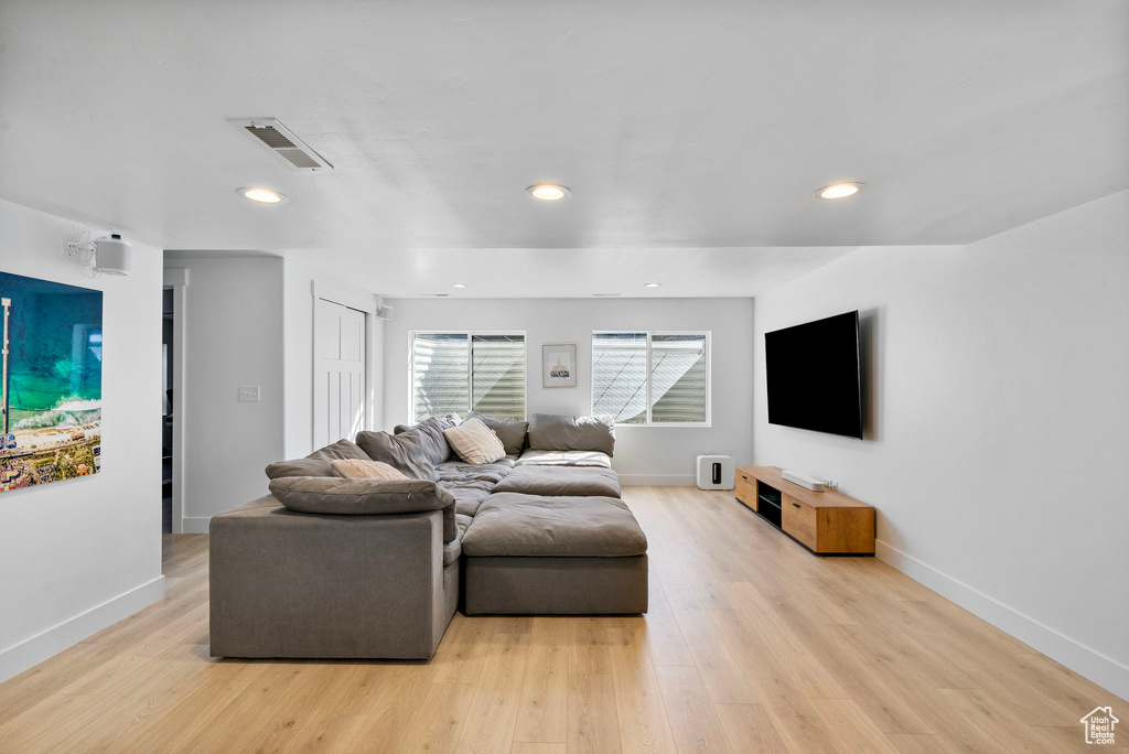 Living area with baseboards, visible vents, and light wood finished floors