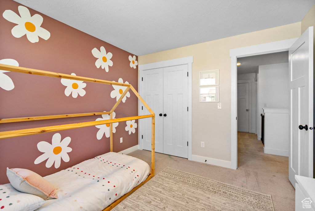 Bedroom featuring carpet flooring, a closet, and baseboards