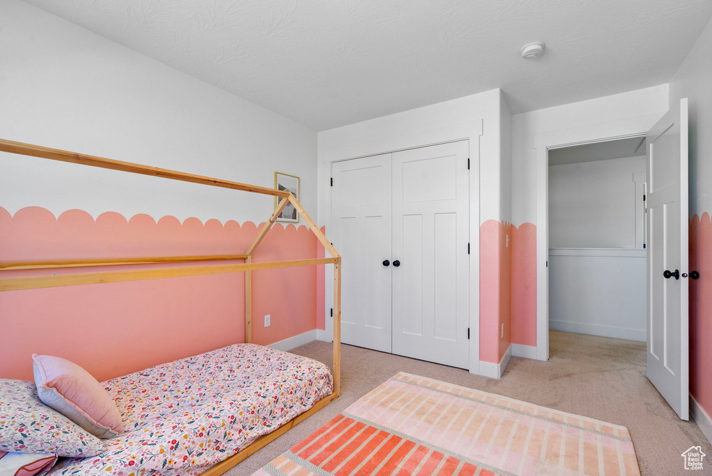 Bedroom with baseboards, a closet, and carpet floors
