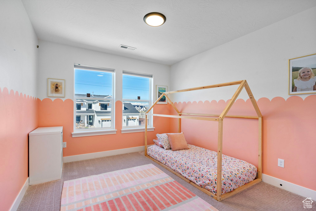 Carpeted bedroom featuring baseboards and visible vents