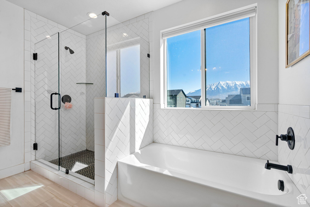Bathroom featuring a bath and a shower stall