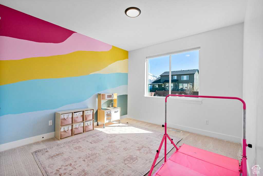 Recreation room featuring carpet flooring, baseboards, and visible vents