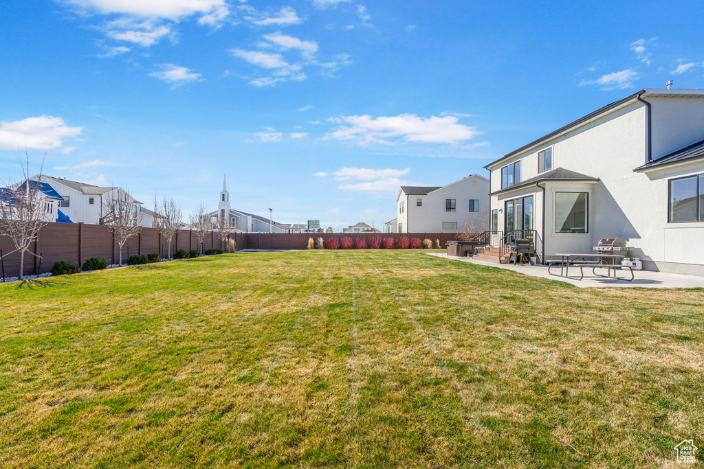 View of yard featuring a fenced backyard, entry steps, a residential view, and a patio area