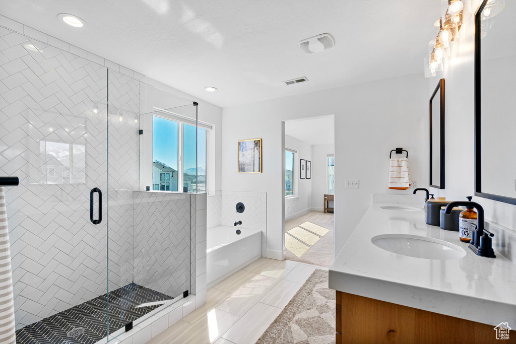 Full bath featuring a bath, visible vents, a shower stall, double vanity, and a sink