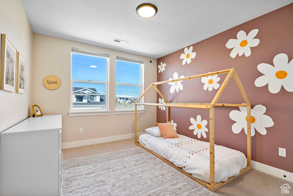 Bedroom featuring baseboards, visible vents, and carpet flooring
