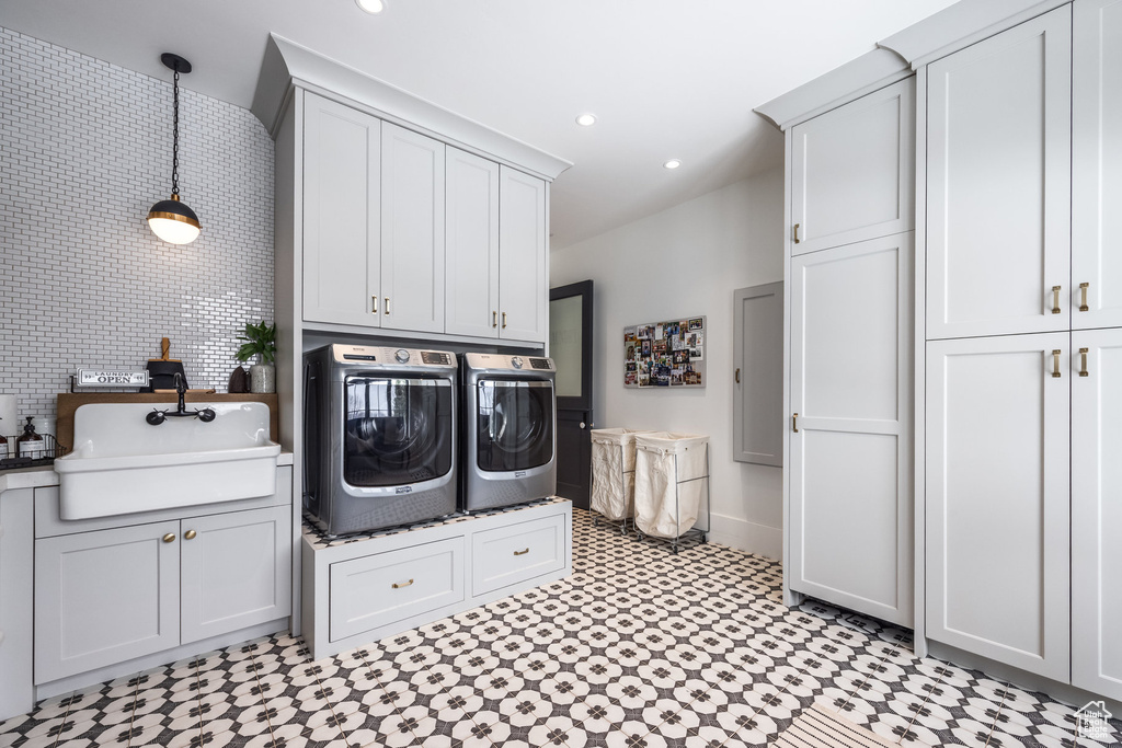 Laundry area with washer and dryer, cabinet space, baseboards, recessed lighting, and light floors