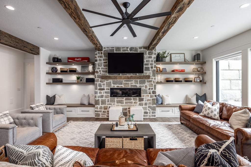 Living area with wood finished floors, beamed ceiling, a ceiling fan, recessed lighting, and a fireplace