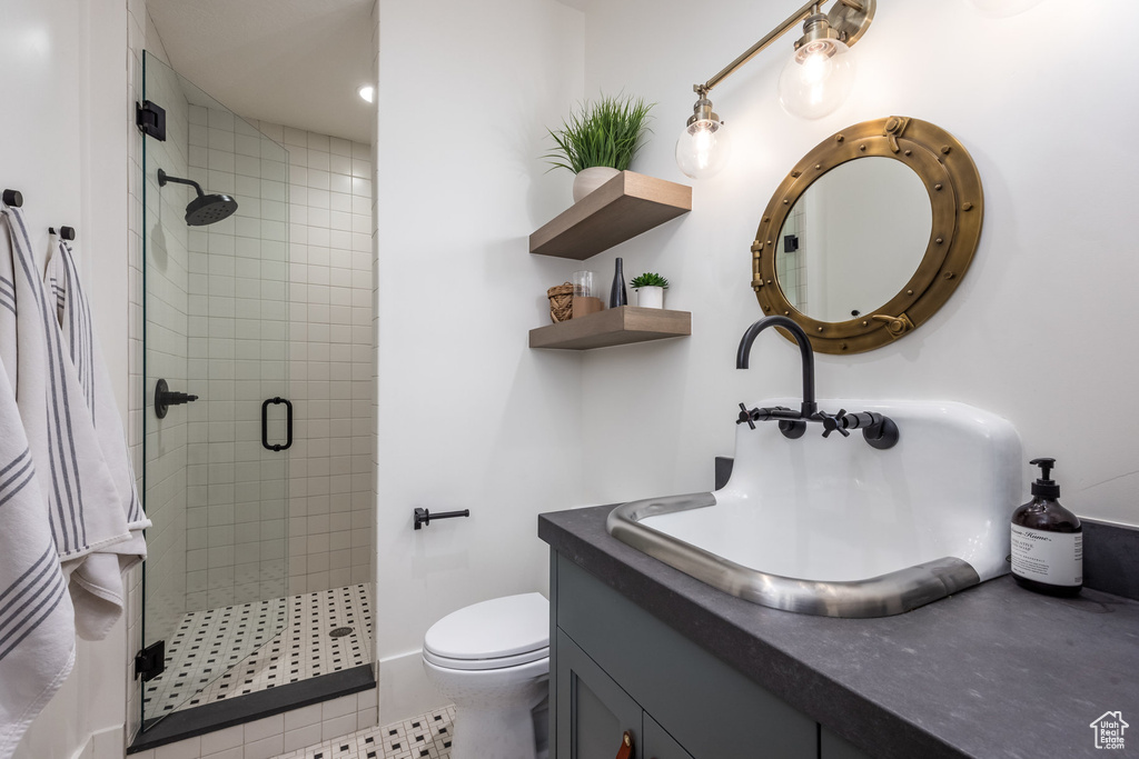Full bath with a shower stall, vanity, toilet, and tile patterned floors